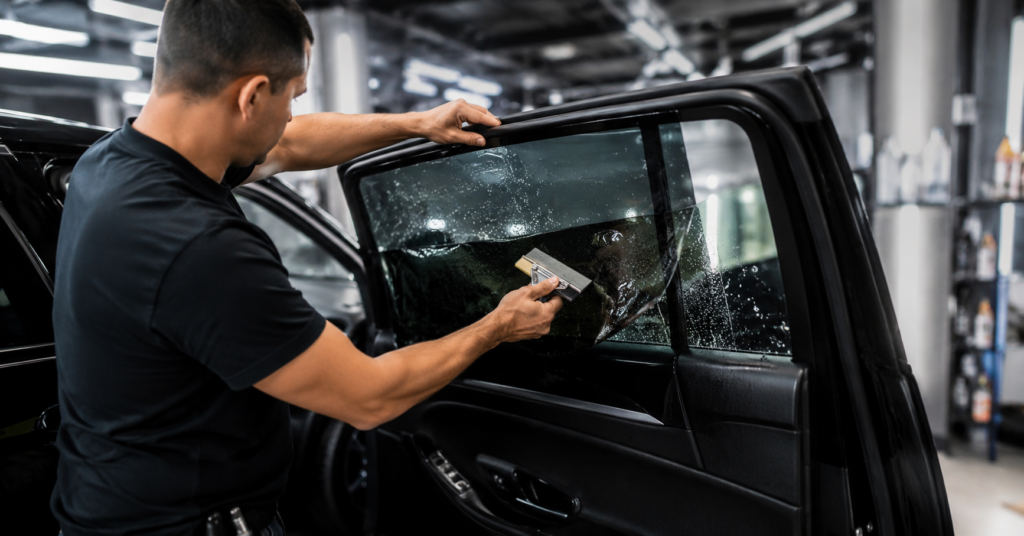 Expert installing high-quality automotive window film for car window tinting near me to improve comfort, reduce glare, and protect the vehicle interior.